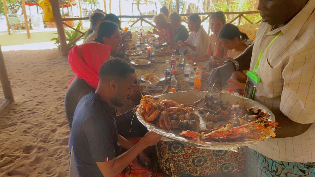 Group of travelers eating seafood lunch at Safari Blue